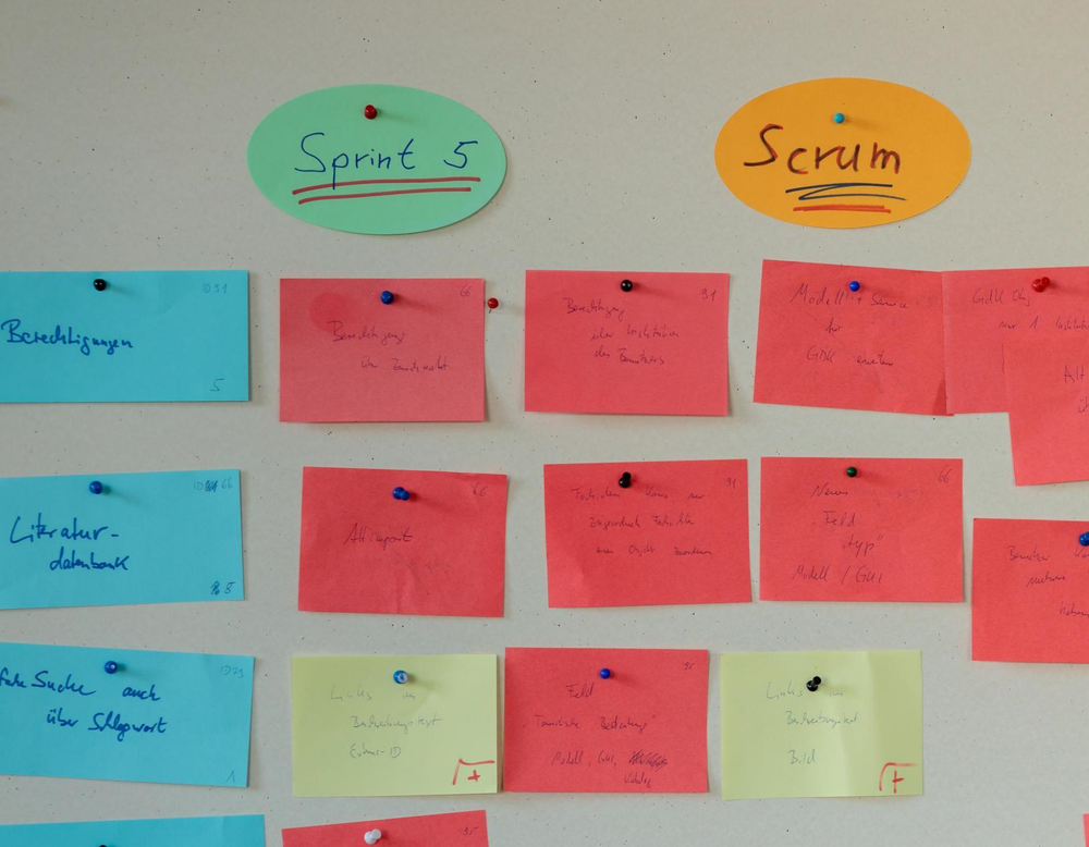 Das Bild zeigt eine Pinwand mit Zetteln. Projekte werden häufig mit agilen Methoden wie Scrum  entwickelt.